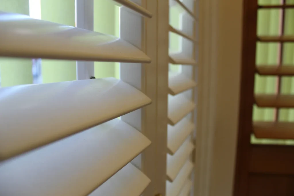Close-up of cream Venetian blind slats angled against a window