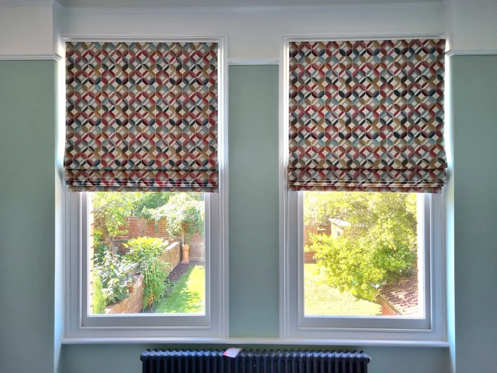 Patterned Roman blinds fitted to two windows overlooking a garden