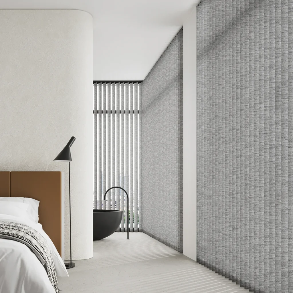 Grey textured vertical blinds beside a bed and a freestanding bath