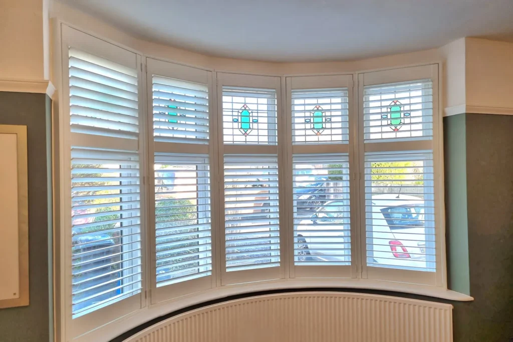 White plantation shutters following the curve of a Bristol bay window