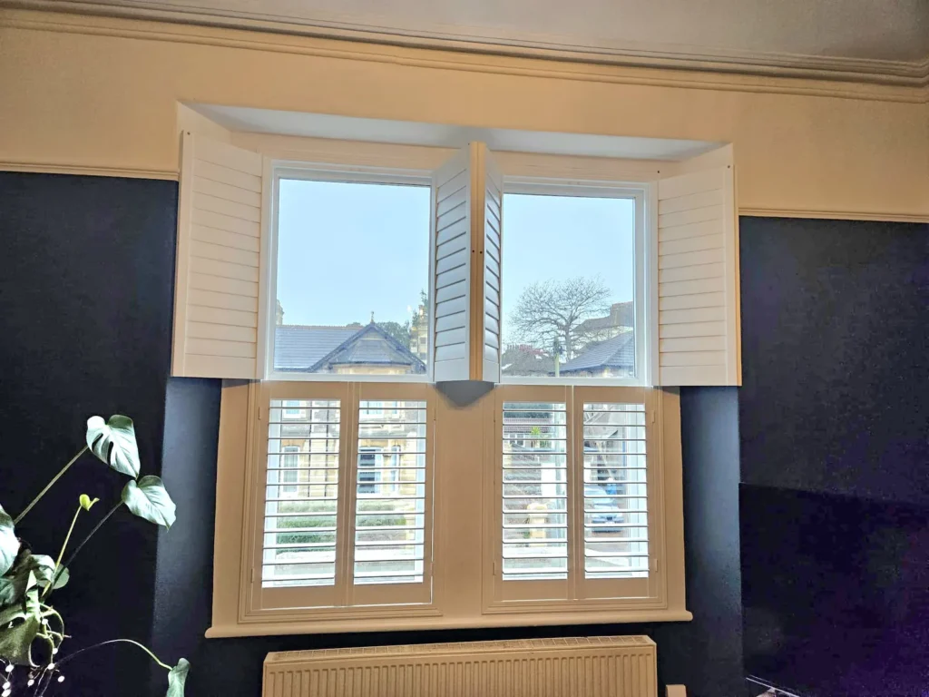 Cafe-style plantation shutters on the lower half of a period bay window