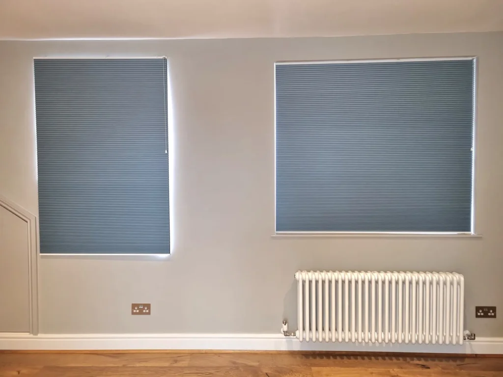 Two blue cellular blinds fitted to a pair of windows in a Bristol room