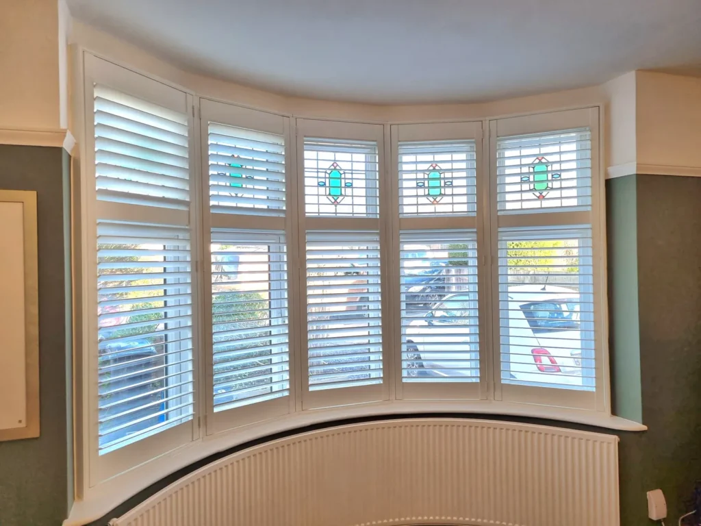 White plantation shutters following the curve of a Bristol bay window