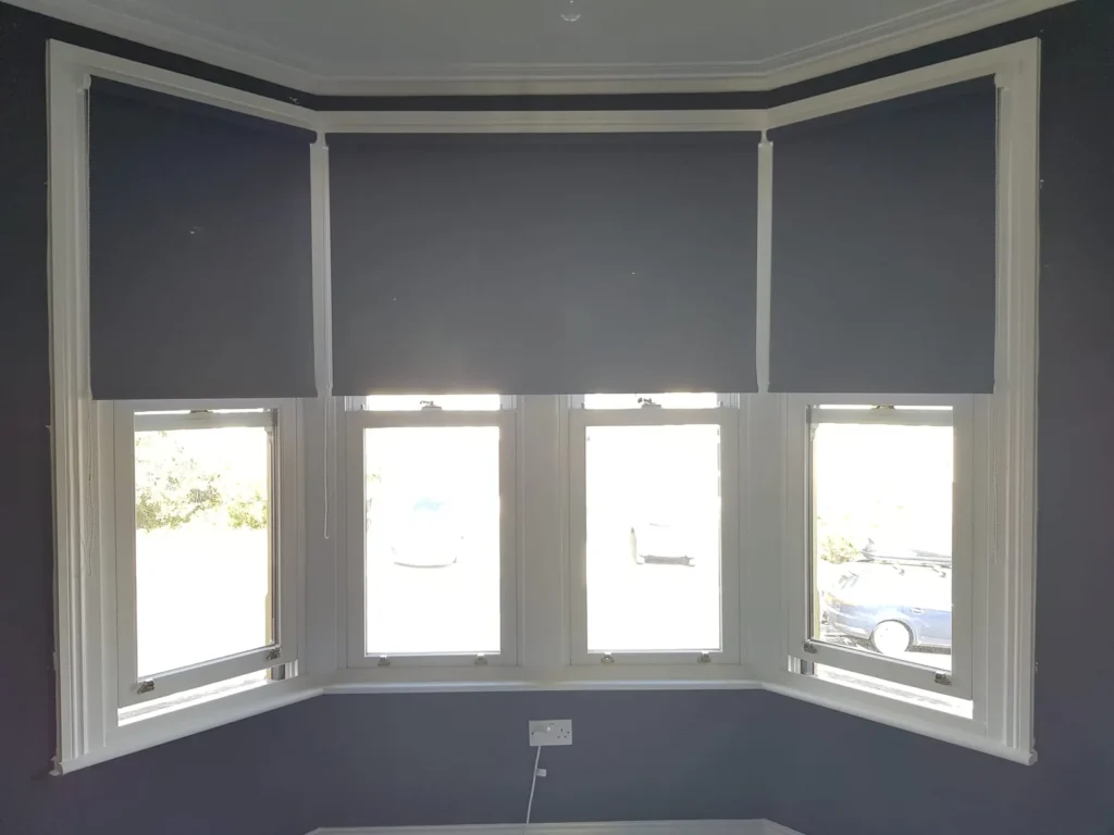 Navy roller blinds fitted to each panel of a four-panel Bristol bay window